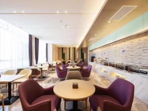 a restaurant with tables and chairs in a room at Lavande Hotel Changchun New District North Lake Longxiang Plaza in Changchun