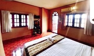 a bedroom with a large bed with a baby on it at Queens Backpackers in Vang Vieng