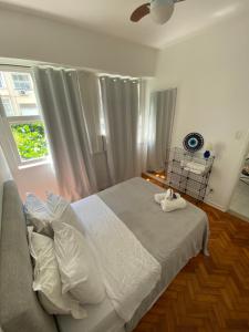 um quarto com uma cama branca e uma janela em Apartment Atlantica no Rio de Janeiro
