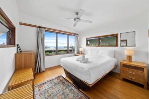 a bedroom with a bed and a large window at Eddies Place in Point Lookout