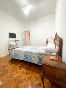 1 dormitorio con 1 cama, vestidor y TV en Apartment Atlantica, en Río de Janeiro