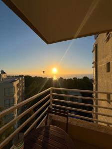 una vista sul tramonto dal balcone di un edificio di Departamento Costa Algarrobo Norte a Yeco