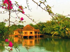 a house in the middle of a body of water at Hoàng Long Resort Villa in Xóm Chua Thanh