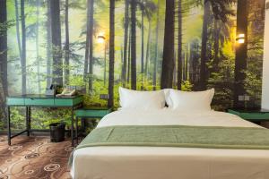 a bedroom with a bed in a forest mural at MB Hotel 