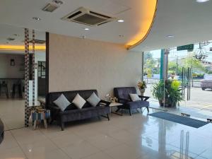 a lobby with two couches and a glass table at BG Business Hotel in Bukit Mertajam