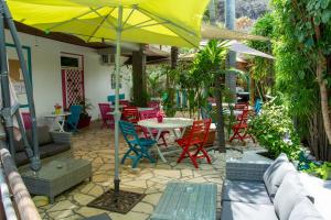 un patio con mesa, sillas y sombrilla en Hotel Ylang Ylang, en Saint-Gilles-les-Bains