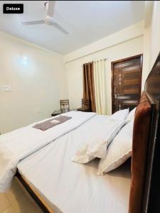 a large white bed in a bedroom with a ceiling at Hotel Green Villa in Rewa