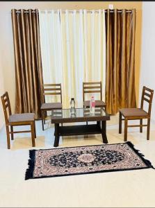 Hotel Green Villa في Rewa: غرفة معيشة مع طاولة وكرسيين