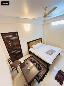 Hotel Green Villa في Rewa: غرفة نوم بسرير وطاولة وكرسي