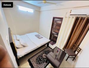 Dormitorio pequeño con cama y mesa en Hotel Green Villa, en Rewa