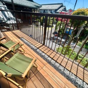 - Balcón con 2 sillas y valla en 湖北 寺の宿- GuestHouse去-来-現Ko-Rai-Gen en Nagahama