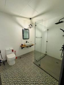 La salle de bains est pourvue d'une douche en verre et de toilettes. dans l'établissement Casa Blanca, à Puerto Galera