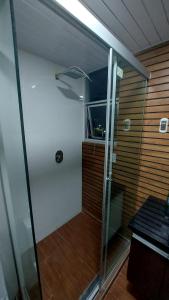 una ducha con puerta de cristal en una habitación en Hermoso y acogedor departamento, en Sucre
