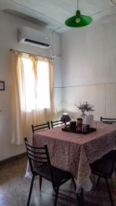 Habitación con mesa con sillas y ventana. en HOSPEDAJE " La Catalina " Ubicada a 15 minutos del Aeropuerto Internacional de Ezeiza con Estacionamiento en Tristán Suárez