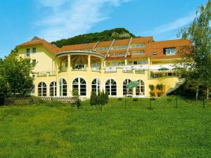 a large yellow building with a red roof at Wellnesshotel Sanct Bernhard in Bad Ditzenbach