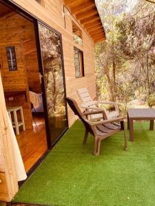 un patio con 2 sillas y una mesa en una casa en Susurro del bosque, en Medellín