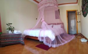 - une chambre avec un lit à baldaquin rose dans l'établissement Salem House Sapa, à Lào Cai