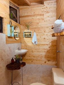 baño de madera con lavabo y aseo en Susurro del bosque, en Medellín
