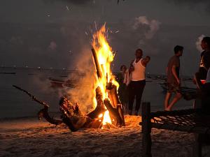 Afro Rooms & Tents in The Beach في كيليندوني: موقد على الشاطئ في الليل