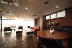 a restaurant with a table and chairs in a room at Frame Hotel Sapporo in Sapporo