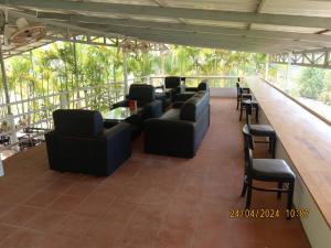 Bohemiaz Resort and Spa Kampot في كامبوت: بار به كنب وكراسي سوداء وكاونتر