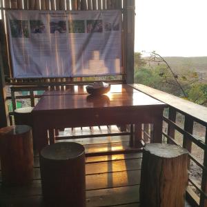 - une table en bois sur une terrasse couverte avec une fenêtre dans l'établissement Banlung Mountain View Treks & Tours, à Banlung