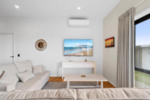 a living room with a couch and a table at The Terraces - Pauanui Holiday Home in Pauanui