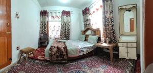 シュリーナガルにあるDouble tree irshadのベッドルーム(ベッド1台、テーブル、鏡付)