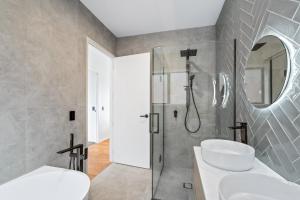 a bathroom with two sinks and a shower at The Terraces - Pauanui Holiday Home in Pauanui +19 photos