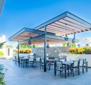 eine Terrasse mit Tischen und Stühlen unter einem Pavillon in der Unterkunft Mountain View Luxury Condo I Céntrico in Puerto Vallarta