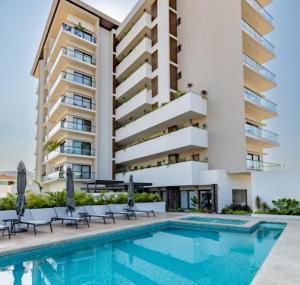 ein Hotel mit Schwimmbad und einem Gebäude in der Unterkunft Mountain View Luxury Condo I Céntrico in Puerto Vallarta