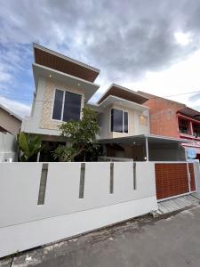 a white fence in front of a house at Sampai Villa Urbanica in Yogyakarta