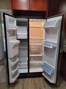 - un réfrigérateur vide avec des portes ouvertes dans la cuisine dans l'établissement THE ARTFULL, à Kent