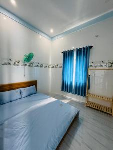 - une chambre avec un grand lit et des rideaux bleus dans l'établissement Biệt Thự Nghỉ Dưỡng Đảo Phú Quý, à Cu Lao Thu