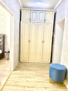 um quarto com um armário com um repousa-pés azul em Комфортные апартаменты на ЭКСО em Prigorodnyy