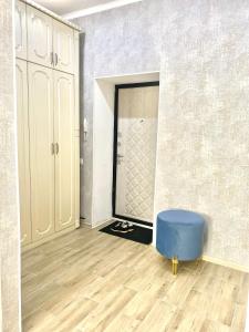 um quarto vazio com um repousa-pés azul em frente a um espelho em Комфортные апартаменты на ЭКСО em Prigorodnyy