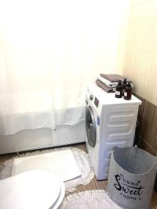 uma máquina de lavar roupa na casa de banho com WC em Комфортные апартаменты на ЭКСО em Prigorodnyy