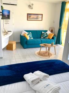 ein Wohnzimmer mit einem blauen Sofa und einem Tisch in der Unterkunft La Kawanaise Blue Lagon in Grand-Bourg