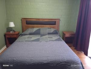 Ce lit se trouve dans une chambre avec 2 tables de chevet et 2 tables. dans l'établissement Alojamiento jv QUILLOTA AMOBLADA, à Quillota