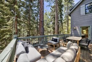 a deck with a couch and a table and chairs at Spacious, Central, & Cozy Cabin Near Lake & Trails in Carnelian Bay