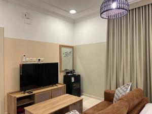 Sidīs的住宿－بوتيك هاوس بغرفة نوم أنيقة，客厅配有平面电视和沙发。