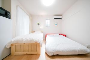 a bedroom with two beds and a window at Simple Stay Minoshima セルフチェックイン in Fukuoka