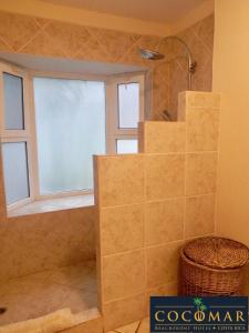 baño con escalera y ventana en HOTEL COCOMAR, en Parrita