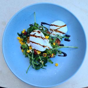 a blue plate with a salad with eggs on it at Novotel Darwin Airport in Darwin