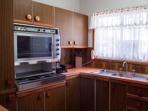 eine Küche mit einer Spüle und einer Mikrowelle in der Unterkunft Collingwood Beach Cottage - Belle Escapes Jervis Bay in Vincentia