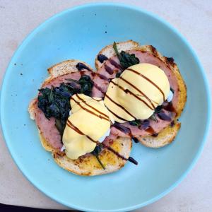 a plate with a sandwich with ham and cheese on it at Novotel Darwin Airport in Darwin