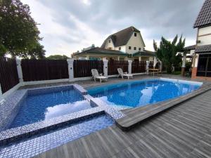 a swimming pool with a wooden deck and a house at A Famosa Resort sunset 1075 villa 4 bathroom 6 bedroom karaoke bbq snooker in Kampong Ulu Pegoh