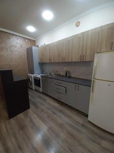 a kitchen with wooden cabinets and a white refrigerator at Sahakyan's guest house in Yerevan