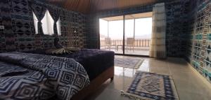 a bedroom with a bed and a window with a view at Remal Wadi Rum Camp & Tour in Disah