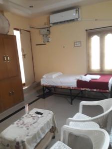 a room with two beds and a table and chairs at Kodali Homestays in Bhadrāchalam